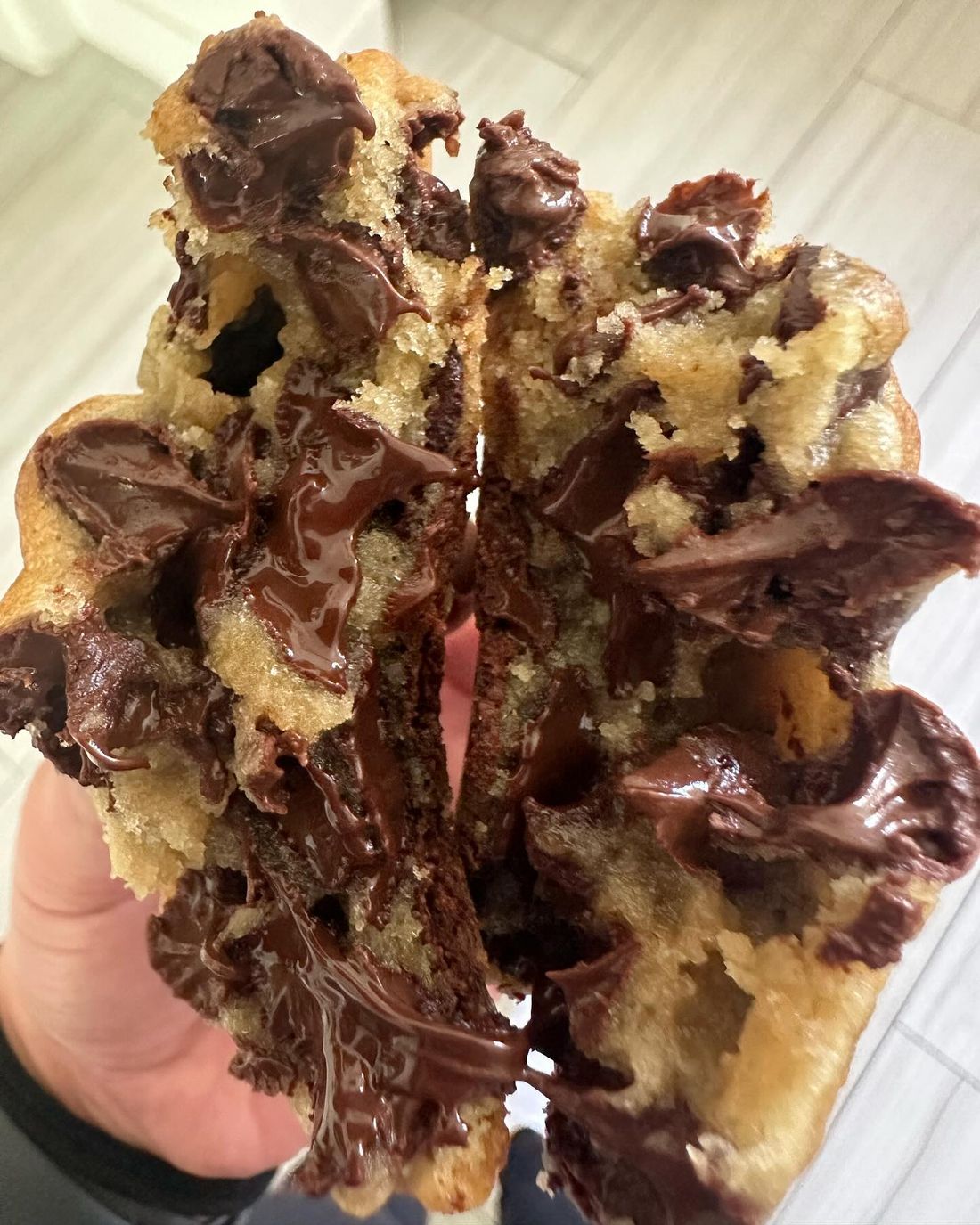 A Double Chocolate Chip cookie broken open with melted chocolate inside